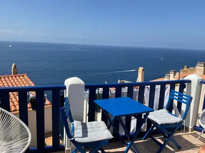 a blue table and chairs on a balcony with the ocean at Serenita - WiFi, Vue Mer, Central in Bonifacio