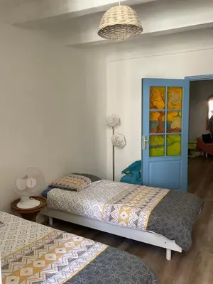 a bedroom with two beds and a blue door at Serenita - WiFi, Vue Mer, Central in Bonifacio