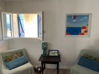 two chairs and a table in a room with two windows at Serenita - WiFi, Vue Mer, Central in Bonifacio