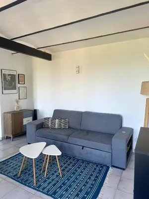 a living room with a blue couch and two chairs at Casa Orsu vue panoramique in Poggio-dʼOletta