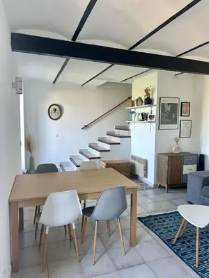 a dining room with a table and chairs and a staircase at Casa Orsu vue panoramique in Poggio-dʼOletta
