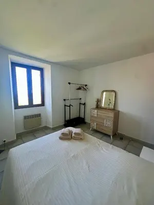 a bedroom with a large white bed and a mirror at Casa Orsu vue panoramique in Poggio-dʼOletta