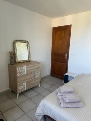 a bedroom with a bed and a mirror and a dresser at Casa Orsu vue panoramique in Poggio-dʼOletta