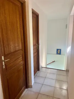 an empty hallway with a wooden door and a tile floor at Casa Orsu vue panoramique in Poggio-dʼOletta