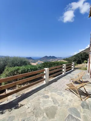 a wooden fence with a table and chairs on a patio at Casa Orsu vue panoramique in Poggio-dʼOletta