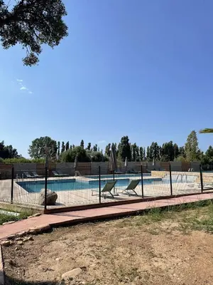 a swimming pool with two chairs and a fence at T2 Saint Cyprien proche de la mer in Lecci