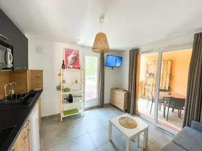 a kitchen with a table and a dining room at T2 Saint Cyprien proche de la mer in Lecci
