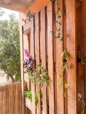 a wooden fence with a window with flowers on it at T2 Saint Cyprien proche de la mer in Lecci
