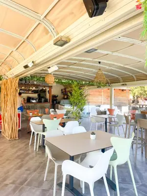 a restaurant with white tables and white chairs at T2 Saint Cyprien proche de la mer in Lecci