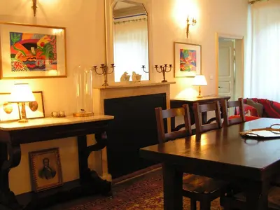 a living room with a table and a fireplace at Maison de caractère spacieuse et confortable, grand jardin , superbes vues in Castello-di-Rostino