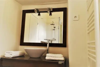 a bathroom with a sink and a mirror at Maison de caractère spacieuse et confortable, grand jardin , superbes vues in Castello-di-Rostino