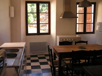a kitchen with a table and chairs in a room at Maison de caractère spacieuse et confortable, grand jardin , superbes vues in Castello-di-Rostino