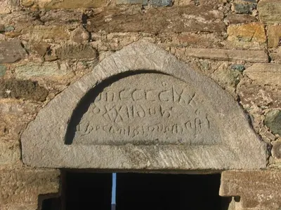 a stone sign on the side of a brick wall at Maison de caractère spacieuse et confortable, grand jardin , superbes vues in Castello-di-Rostino