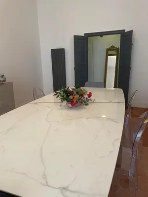 a white marble table with a bouquet of flowers on it at 120 m2, hyper centre cathédrale proximité plage in Ajaccio