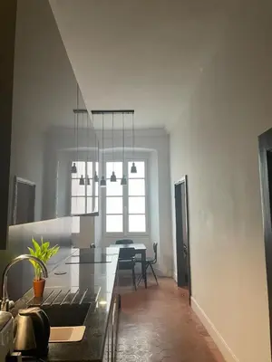 a kitchen with a dining table and a chandelier at 120 m2, hyper centre cathédrale proximité plage in Ajaccio