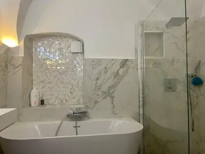 a white bathroom with a tub and a shower at 120 m2, hyper centre cathédrale proximité plage in Ajaccio