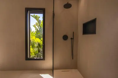 a glass shower in a room with a window at Villa MARE E MACCHIA in Lecci