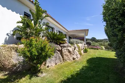 a house with rocks and plants in the yard at Villa MARE E MACCHIA in Lecci