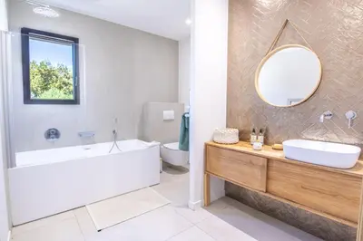 a bathroom with a tub and a sink and a mirror at Villa MARE E MACCHIA in Lecci