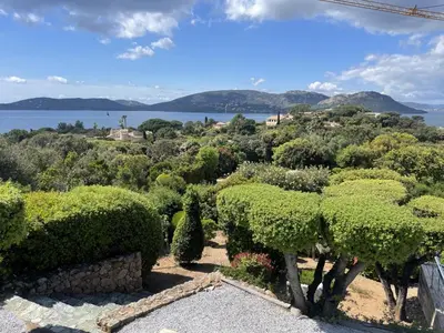 a garden with bushes and a view of the water at Casadelys in Cala Rossa