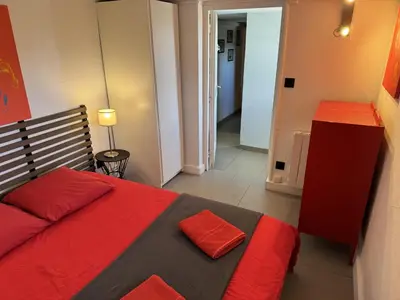 a bedroom with a red and black bed and a hallway at Casadelys in Cala Rossa