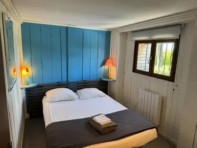 a bedroom with a bed with blue walls and a window at Casadelys in Cala Rossa