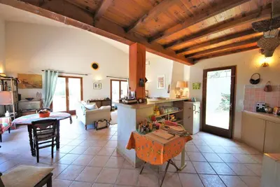 a large kitchen and living room with a table and chairs at Maison Famiglia Sérénité et nature in Porto-Vecchio