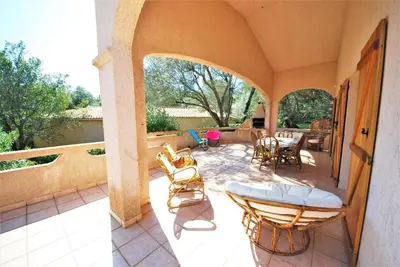 a patio with chairs and a table and a table and chairs at Maison Famiglia Sérénité et nature in Porto-Vecchio