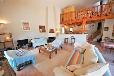 a living room filled with furniture and a staircase at Maison Famiglia Sérénité et nature in Porto-Vecchio