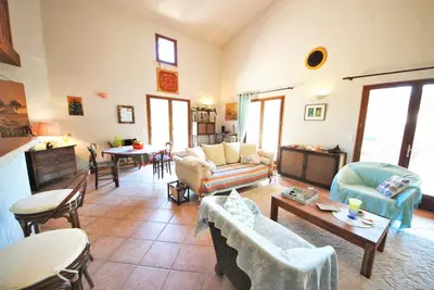 a living room with couches and chairs and tables at Maison Famiglia Sérénité et nature in Porto-Vecchio