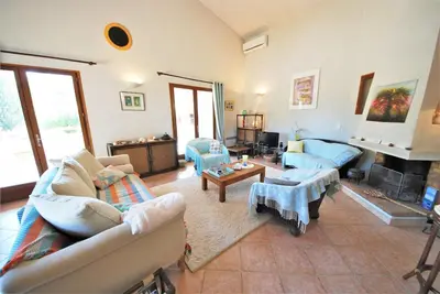 a living room with couches and a fireplace at Maison Famiglia Sérénité et nature in Porto-Vecchio