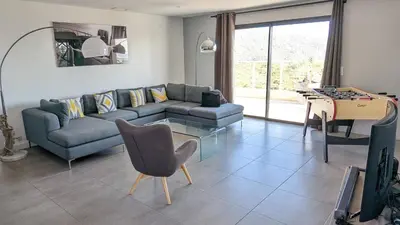 a living room with a couch and a table at Superbe villa moderne sur Capo di Muro in Coti-Chiavari