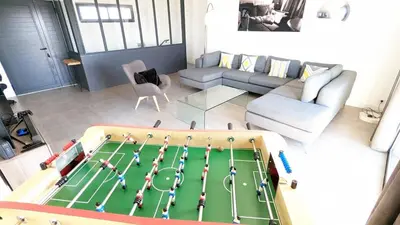 a living room with a large table with a soccermatch at Superbe villa moderne sur Capo di Muro in Coti-Chiavari