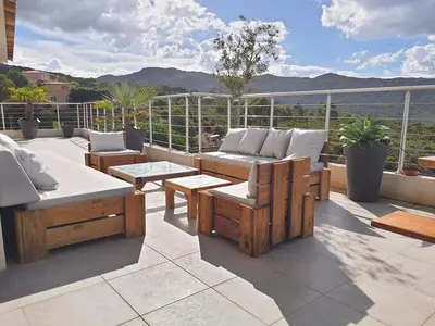 a patio with couches and tables on a balcony at Superbe villa moderne sur Capo di Muro in Coti-Chiavari