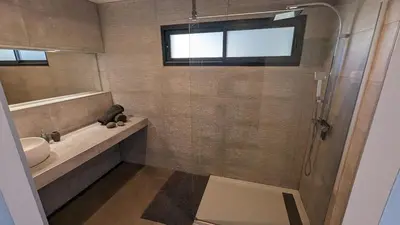 a bathroom with a sink and a shower with a mirror at Superbe villa moderne sur Capo di Muro in Coti-Chiavari