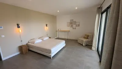 a bedroom with a bed and a table in it at Superbe villa moderne sur Capo di Muro in Coti-Chiavari