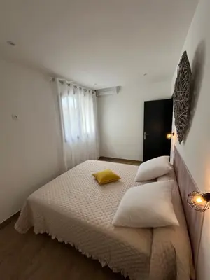 a white bedroom with a bed with two pillows at Appartement T2 Porticcio in Porticcio