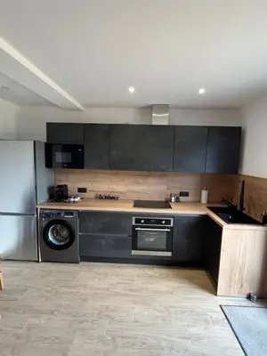 a kitchen with black cabinets and a dishwasher at Appartement T2 Porticcio in Porticcio