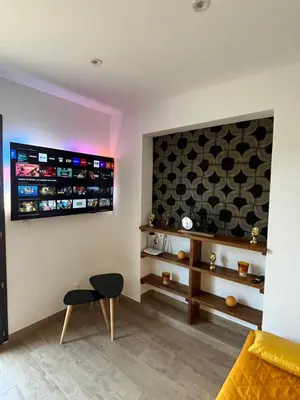 a living room with a yellow couch and a tv at Appartement T2 Porticcio in Porticcio