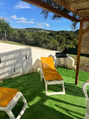 a patio with two chairs and a table and a grill at Appartement T2 Porticcio in Porticcio
