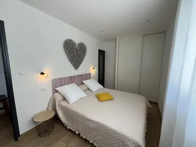 a bedroom with a bed with a heart on the wall at Appartement T2 Porticcio in Porticcio