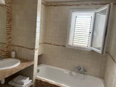 a bathroom with a tub and a sink and a window at Valle Di Casa in Sotta