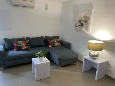 a living room with a blue couch and two tables at Valle Di Casa in Sotta