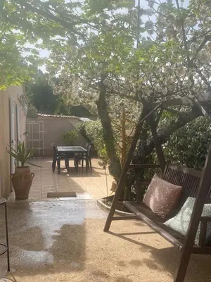a patio with a table and a swing under a tree at Maison T3 in Piana