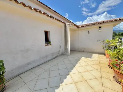 a patio of a white building with potted plants at Villa avec piscine à Lecci in Lecci