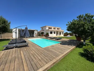 a house with a swimming pool and a wooden deck at Villa avec piscine à Lecci in Lecci