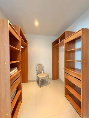 a walk in closet with wooden cabinets and a chair at Villa avec piscine à Lecci in Lecci