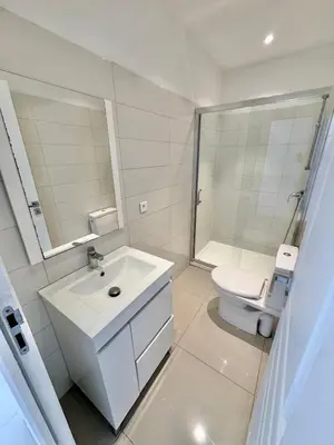 a white bathroom with a sink and a toilet at Villa avec piscine à Lecci in Lecci