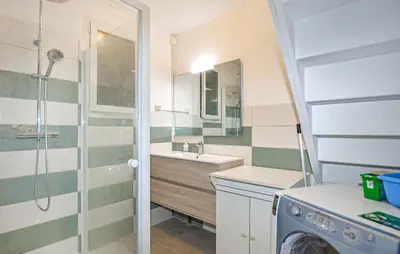 a bathroom with a sink and a washing machine at Villa Piscine Privée in Moriani Plage