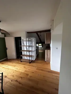 an empty room with a wooden floor and a spiral staircase at Charming apartment in Corsican Village in Vescovato